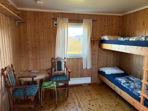 a room with a desk and a table and a bed at Skåbu Camping in Skåbu