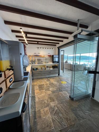 Una cocina con dos fregaderos y una ducha de cristal. en Panormos Beach Hotel Skopelos, en Panormos Skopelos