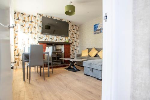 a living room with a couch and a table at Spa & Rose Cottages Gilsland in Gilsland