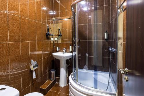 a bathroom with a toilet and a sink and a shower at Rustaveli Inn რუსთაველი ინნ in Rustavi