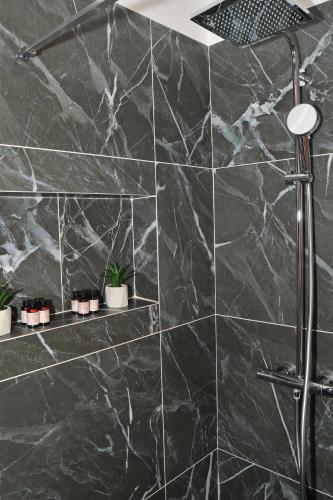 a bathroom with black marble walls and a shower at Anastasia Meteora Residence in Kalabaka