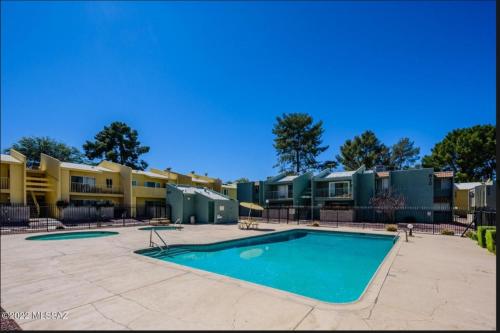 una piscina frente a algunos complejos de apartamentos en Mountain View Condo with Pool, en Tucson