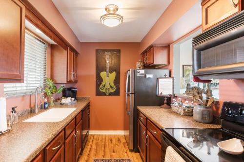 a kitchen with a stainless steel refrigerator and wooden cabinets at Downtown Riverfront Condo unit 780 in Nashville
