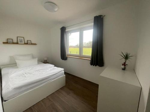 En eller flere senge i et værelse på Ferienhäuser Wintermoor