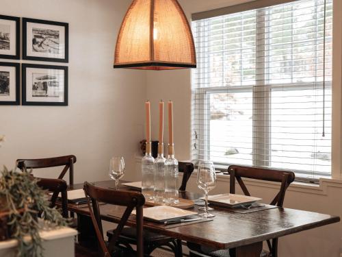 un comedor con una mesa con sillas y una lámpara en Mountain Escape Ski-In Ski-Out Laurentians, en Saint-Faustin
