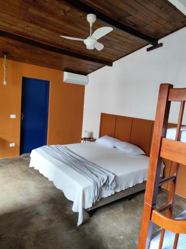 a bedroom with a bed with a blue door at Chalés Com Quadra de Areia in São Sebastião