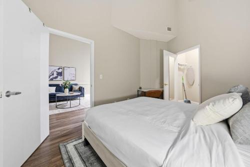 een witte slaapkamer met een bed en een woonkamer bij Modern 1BR perfect for extended visits in New Haven