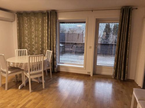 Un comedor con mesa y sillas y ventanas. en Kisteberglia, en Stavanger