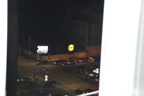 a view of a street at night with cars parked at Iza Suite in Craiova
