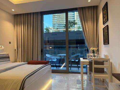 um quarto com uma cama e uma mesa e uma varanda em The Sterling 4 sleep with AC parking and pool em Sabkhah