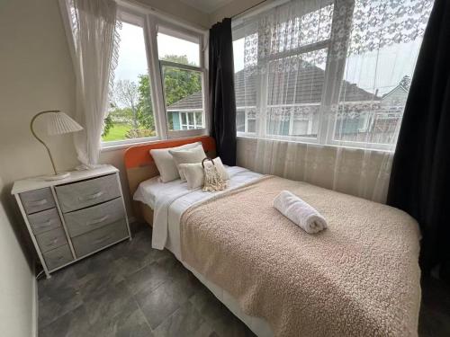Un dormitorio con una cama y una ventana en Northcote Holiday Home Rooms, en Auckland