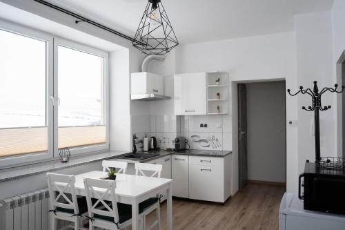 Una cocina blanca con una mesa y sillas blancas. en Tatry view apartment, en Suchá Hora