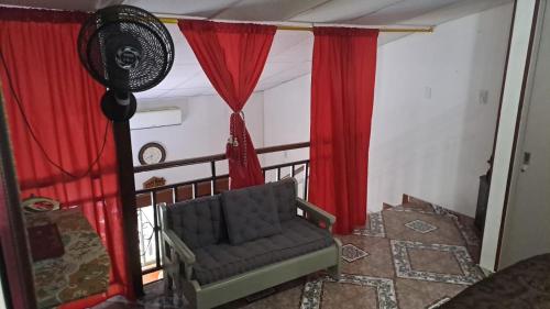 a living room with red curtains and a chair at samargo in Cali