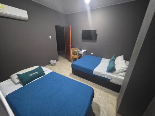 a hotel room with two beds and a television at Mendoza Jeps Barranquilla in Barranquilla