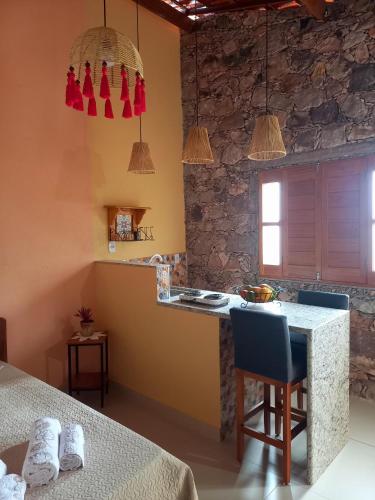 a kitchen with a counter and a table with chairs at Loft de Cristal Igatu in Andaraí