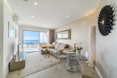 a living room with a couch and a table and chairs at Sundream Escape - Penthouse with ocean view, airco, heated pool in Adeje