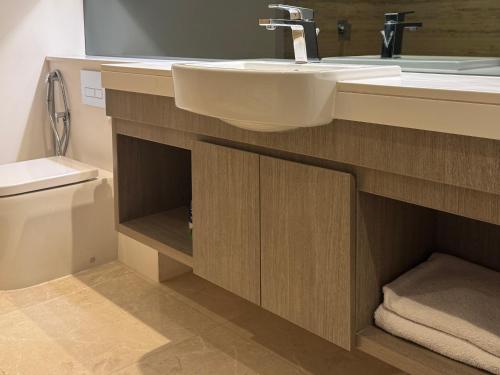 um banheiro com pia e vaso sanitário em The Sterling 4 sleep with AC parking and pool em Sabkhah