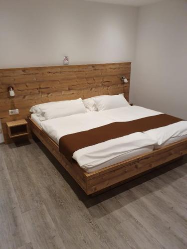 a bedroom with a large bed with a wooden headboard at Gasthaus Adler in Calw