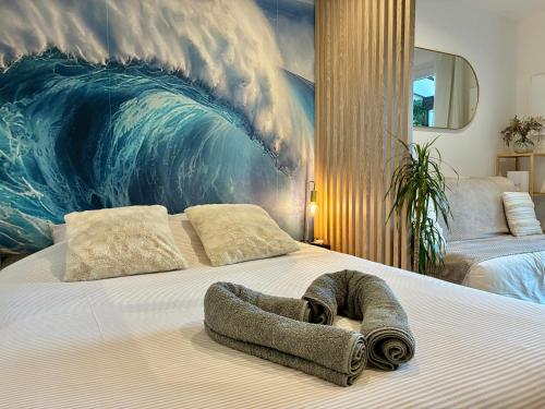 Una cama con una gran pintura de olas sobre ella. en DUNE Océan Luxe Appartement, Accès Plage privé, Parking & Wifi 50m Océan Surf, en Seignosse