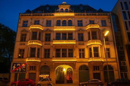 Un gran edificio con coches aparcados delante. en Downtown Landmark near Checkpoint Charlie - fully preserved, en Berlín