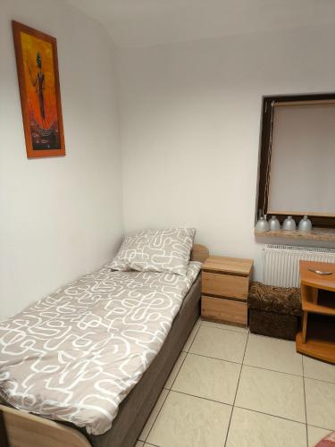 a bed sitting in a room with a window at Noclegi w mieście in Kozienice