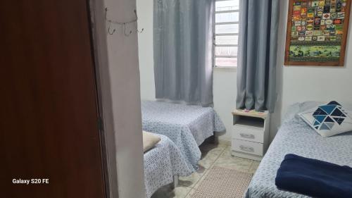 a bedroom with two twin beds and a window at hostel da Eide - Inhotim in Brumadinho