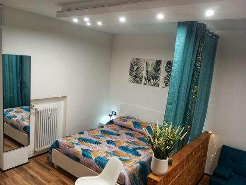 un dormitorio con una cama y una silla en RELAIS SUITE Modena Parc, en Módena