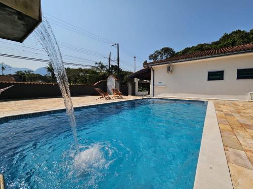 a swimming pool with a water fountain at Chalés Com Quadra de Areia in São Sebastião