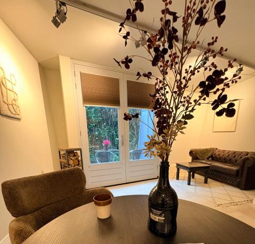 a living room with a table and a vase with flowers at De Meuleberg Boutique Suites