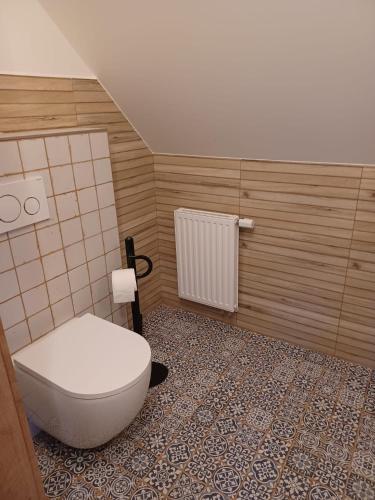 a bathroom with a toilet and a tile floor at Apartmány Albipolis - Hořec a Modřín in Vrchlabí