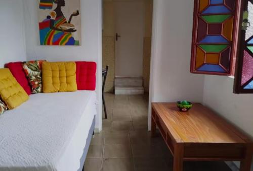 una stanza con un divano bianco e un tavolo di legno di Casa Centro Histórico a Diamantina