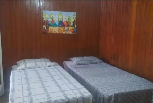 2 letti singoli in una camera con pareti in legno di Casa Centro Histórico a Diamantina