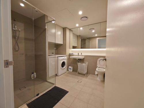 a bathroom with a shower and a toilet and a sink at Modern Comfort Stay - Near Stadiums Green Spaces-19 in Sydney