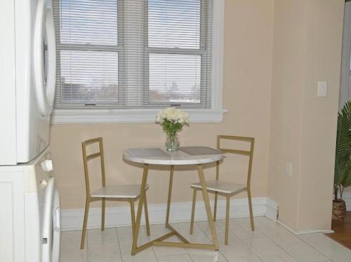 a table with two chairs and a vase of flowers on it at The Cozy Luxe Retreat, Central West End in Saint Louis