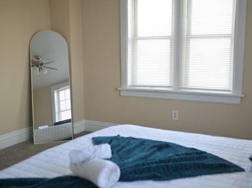 a bedroom with a bed and a large mirror at The Cozy Luxe Retreat, Central West End in Saint Louis