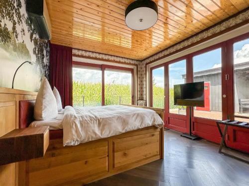 a bedroom with a bed and a flat screen tv at Holiday Home in Friesland near Canal & Lake in Schuilenburg