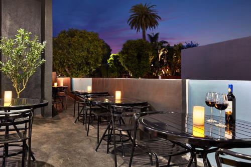 a row of tables and chairs with wine glasses at Elan Hotel in Los Angeles