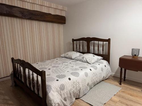 a bedroom with a wooden bed with a white comforter at Maison vintage à Montdauphin in Montdauphin