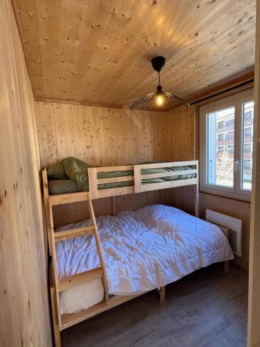 a bedroom with two bunk beds in a cabin at Lodge des Mélèzes in Ancelle