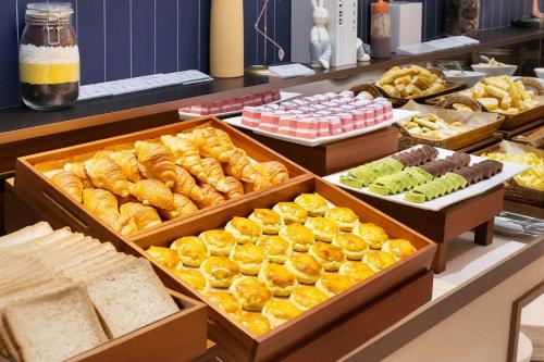 een buffet gevuld met verschillende soorten brood en gebak bij Holiday Inn Express Shanghai Putuo by IHG in Shanghai
