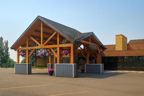 a large wooden building with flowers in a parking lot at Super 8 by Wyndham Spruce Grove in Spruce Grove