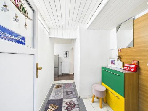 Apartment in Kordel في Kordel: ممر به خزانة خضراء وباب