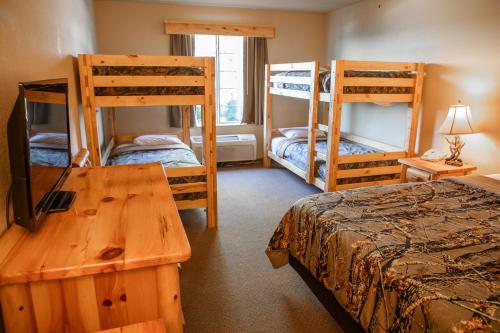 a room with three bunk beds and a table at Deer Valley Lodge in Barneveld