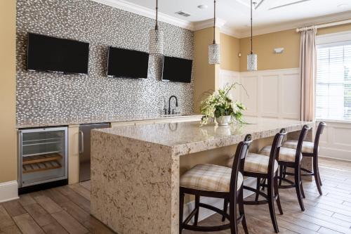 a kitchen with a large island with bar stools at Kasa Southside Wilmington in Wilmington