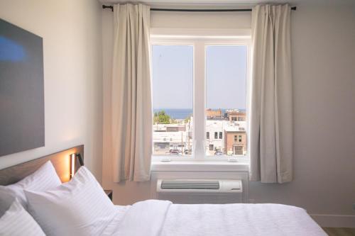 a bedroom with a bed and a large window at Boardwalk Suites & Residences By Kasa in Traverse City