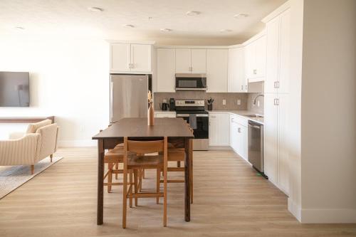 a kitchen with white cabinets and a table and chairs at Boardwalk Suites & Residences By Kasa in Traverse City