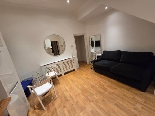a living room with a black couch and a mirror at Camden Mia Apa in London