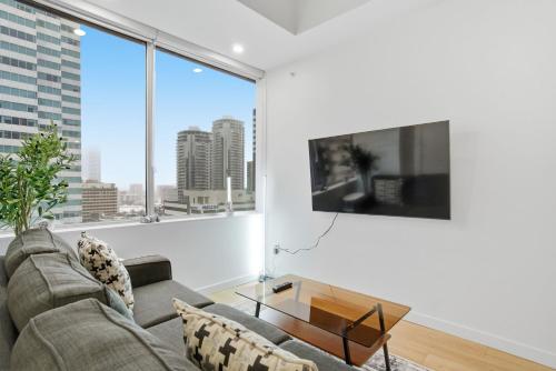 a living room with a couch and a large window at Luxury 1Beds and 2Beds in Downtown Edmonton close to Rogers in Edmonton