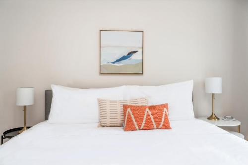 a bedroom with a white bed with two lamps at Kasa Bryn Mawr Minneapolis in Minneapolis