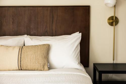 a bed with white pillows and a wooden headboard at The Vic By Kasa in Traverse City